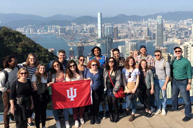 A student group poses in front of a cityscape during a field experience course in China.