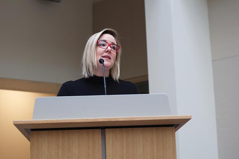 A woman stands at a podium.